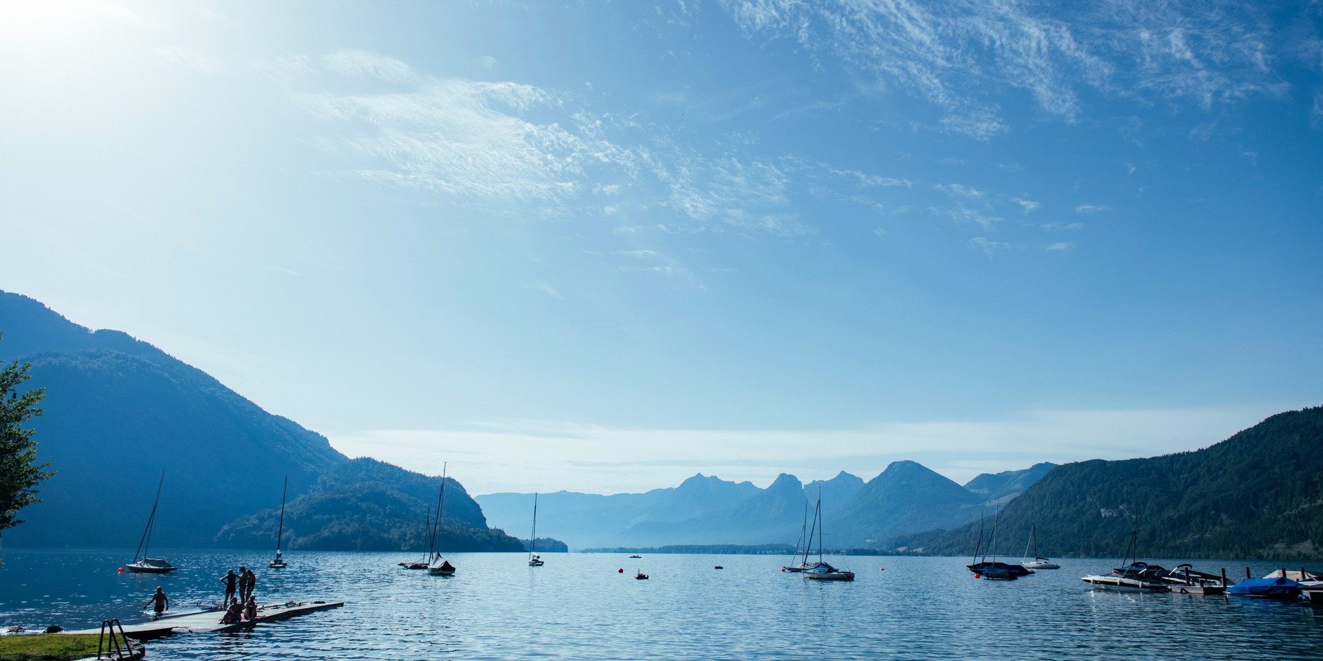 Segelboote am Wolfgangsee in Österreich mit Bergen im Hintergrund an einem sonnigen Tag