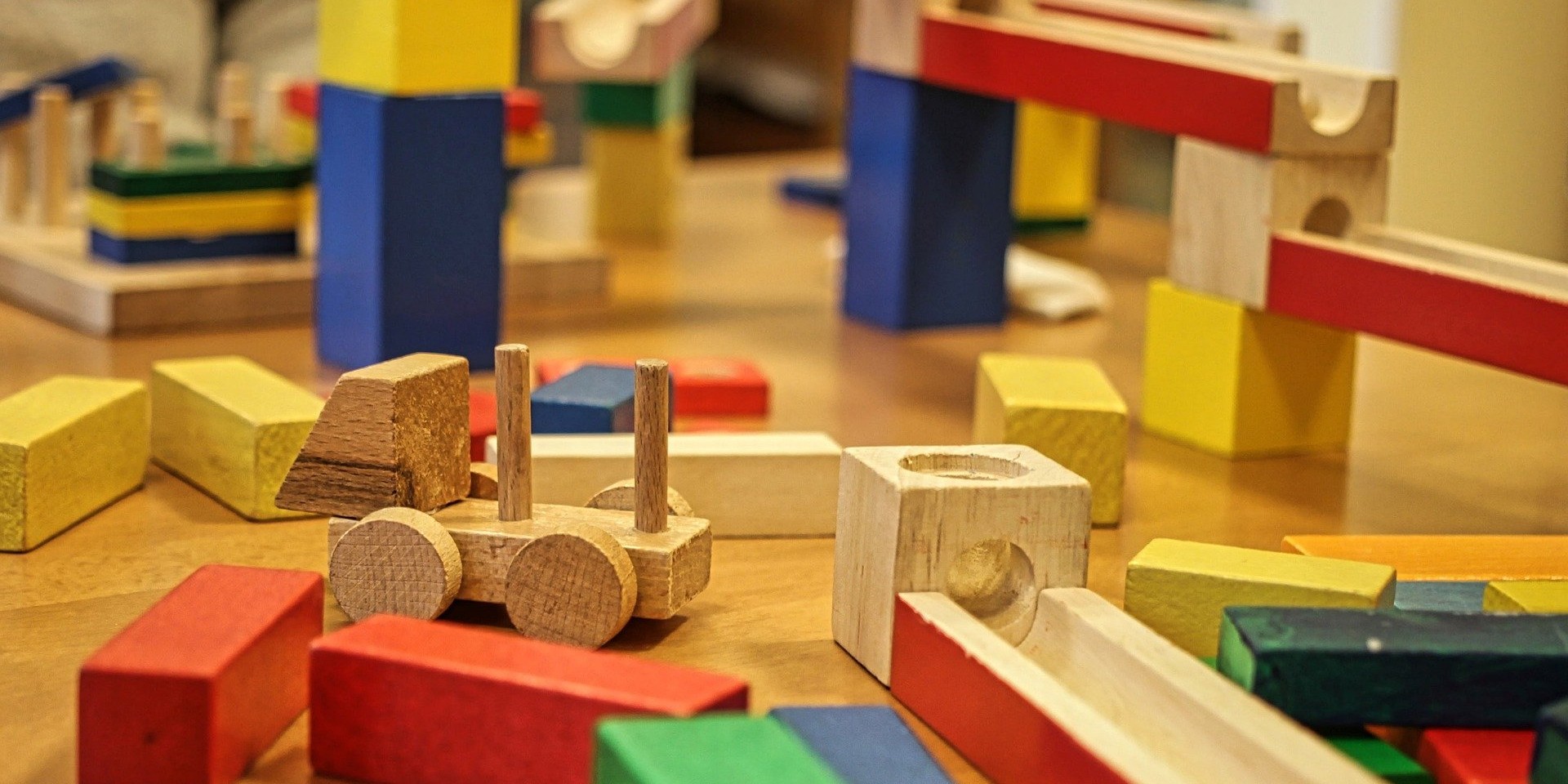 Holzbausteine und Murmelbahn auf Holztisch, bunte Spielsachen