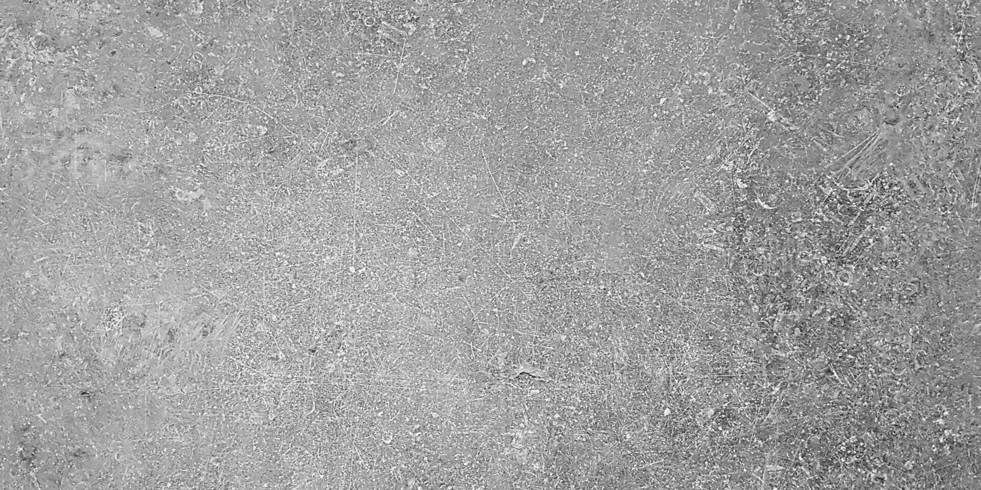 Betonoberfläche mit feinen Kratzern und Unebenheiten in Grau
